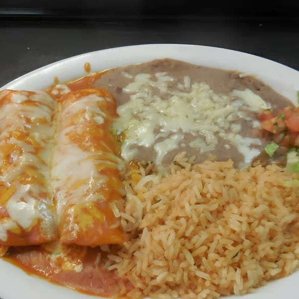 Two cheese enchiladas with red sauce, rice, and refried beans with melted cheese on a white plate.